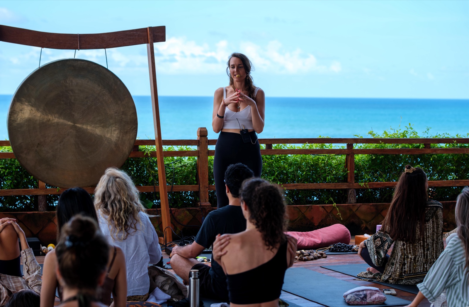 Christa speaking to a group during a gong ceremony overlooking the ocean
